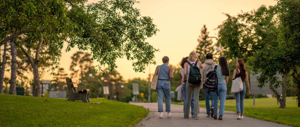 Group of college students walking down sidewalk on campus