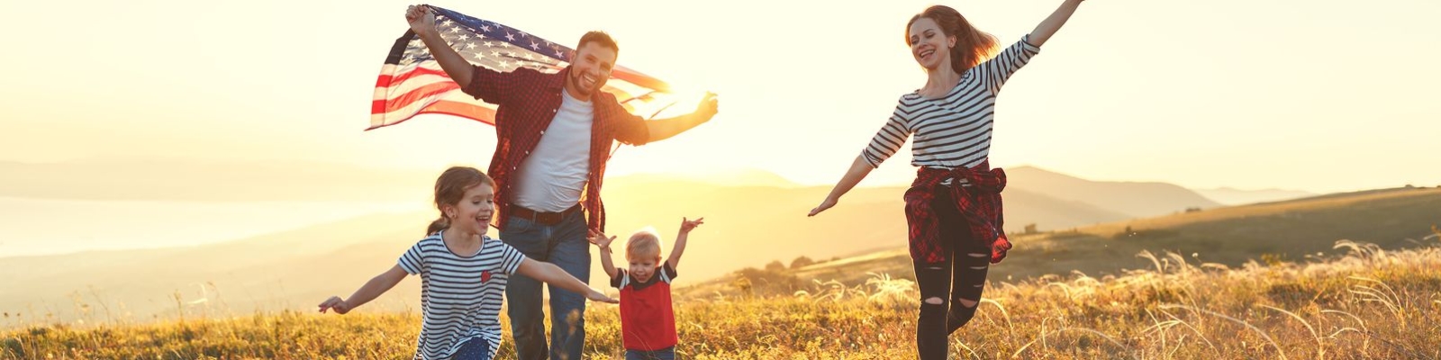 Family in field flying american flag